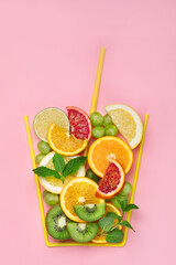 A glass made of differents fruits on colorful background. Minimalism design concept.