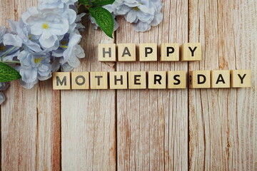 Happy Mothers day alphabet letter with flower decoration on wooden background