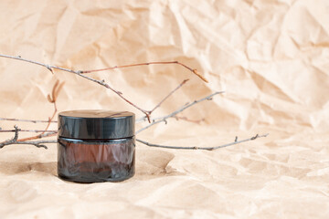 Cometic bottles made of amber glass on crumpled craft paper. Skin care products packaging design. Spa concept.