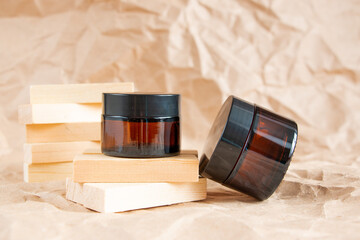 Cometic bottles made of amber glass on crumpled craft paper. Skin care products packaging design. Spa concept.