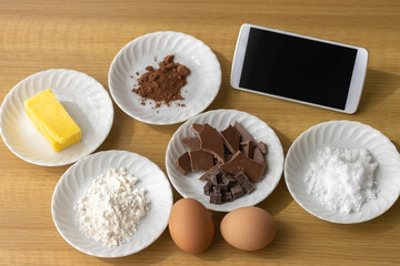 スマートフォンを見てチョコレート菓子を作るイメージ