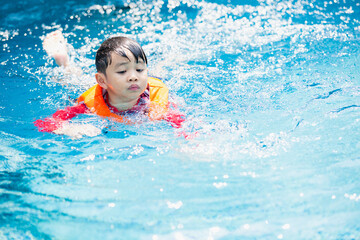 Fototapeta na wymiar kid boy swimming pool exercise in holiday activities. swim practice sports.