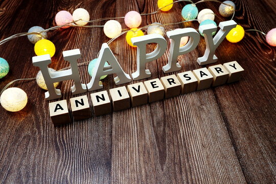 Happy Anniversary alphabet letter with LED cotton balls on wooden background