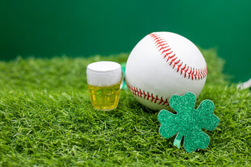 Baseball with beer and Shamrock clover for St. Patrick's Day on green grass