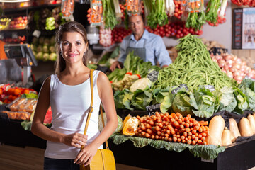 Obraz premium Portrait of cheerful female customer and friendly shop assistant in vegetable shop