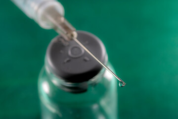 selective focud of syringe and vial for vaccine on a green background, in Brazil