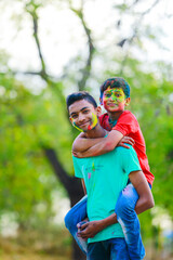 Naklejka premium Cute indian little child playing holi. Holi is colors festival in india