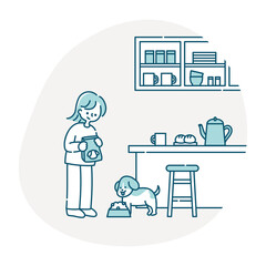 キッチンで犬にごはんをあげる女性