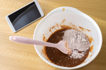 スマートフォンを見てチョコレート菓子を作るイメージ
