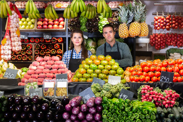 Fototapeta na wymiar Cheerful male and female shop assistants in vegetable shop
