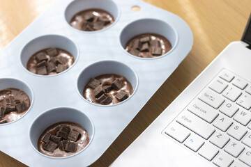 ノートパソコンを見てチョコレート菓子を作るイメージ