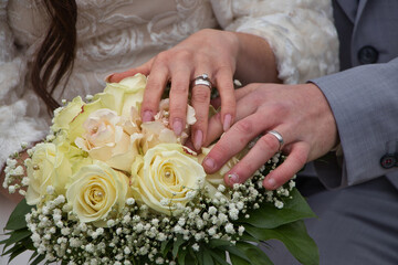 Obraz na płótnie Canvas Wedding rings on fingers hold together
