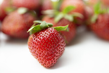 Juicy ripe strawberries on a white plate.