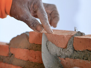 Brick worker set up concrete layer between bricks 