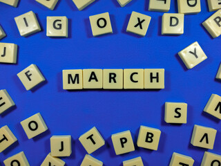 Alphabets on blue background with text MARCH.