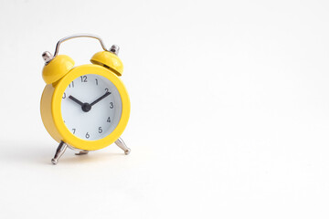 Small yellow alarm clock with bell isolated on white background.