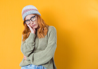 Bored indifferent beautiful woman feeling sleepy and reluctant stare apathy, lean face on palm look camera unemotional, isolated on yellow background. Nostalgia concept