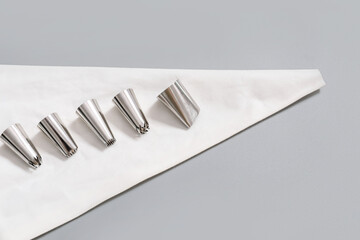 Pastry bag and different tips on grey background
