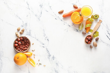 Bowl with nuts, fresh products and glass of juice on light background