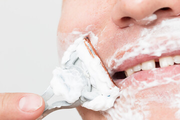 the man shaves his face