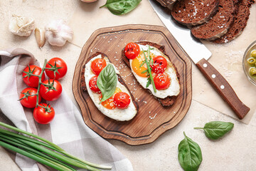 Wooden board with fresh tasty bruschettas on light background