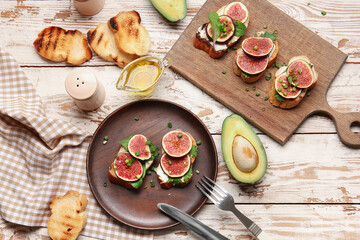 Plate and board with fresh tasty bruschettas on wooden background