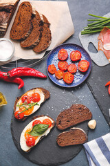 Slate plate with fresh tasty bruschettas on dark background