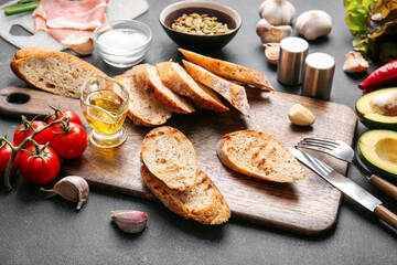 Composition with ingredients for tasty bruschettas on dark background