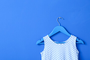 Hanger with dress on color background