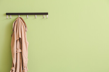 Hanger with coat on color background - obrazy, fototapety, plakaty