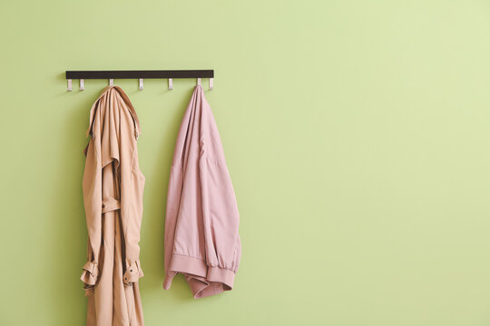 Hanger with clothes on color background