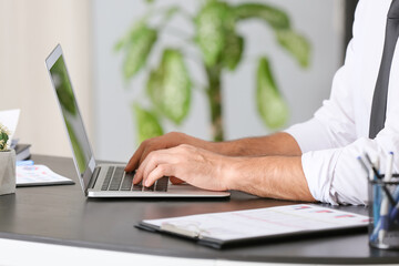 Young businessman working with laptop in office