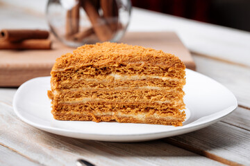 Closeup on slice of sweet honey cake on the wooden table