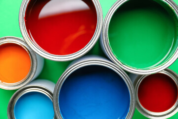 Cans of paints on color background