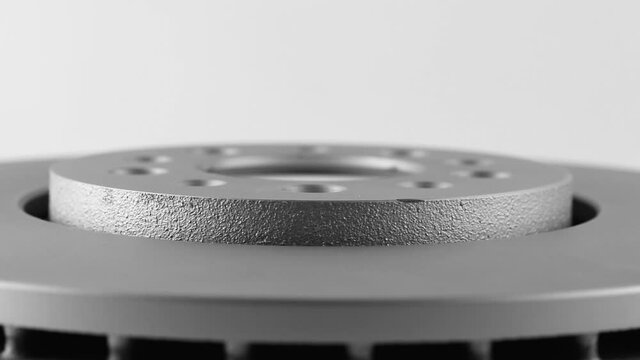 rotation of car brake disk side view. abstract background with metal of silver color with holes