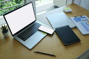 Accountant workplace with laptop computer, smart phone and document on wooden table.