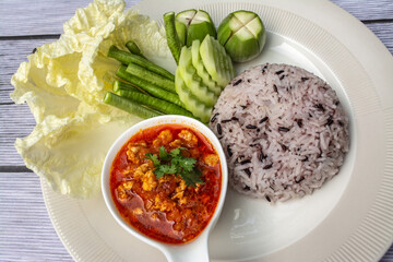 Nam phrik ong is a popular Thai food in Northern Thailand. Composition with rice, pork and fresh vegetables as cucumber, Chinese cabbage, cow pea, eggplant. 