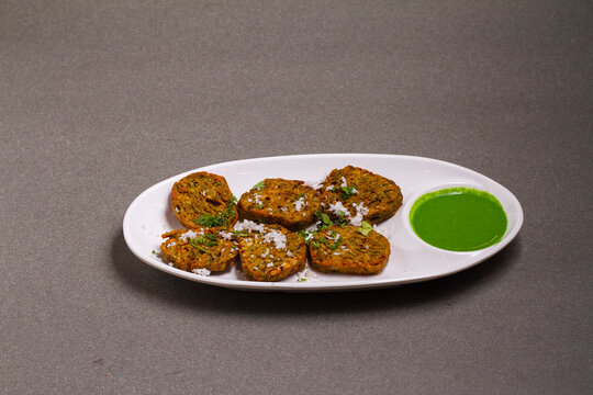 Cilantro cake or Kothimbir Vadi is a popular Maharashtrian cuisine made with cilantro leaves. served with tomato ketchup. selective focus
