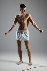 Obraz premium an athlete in shorts gestures with his hands in a bright room in full growth