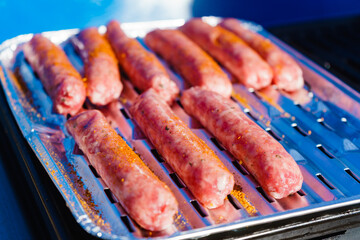 Sausages meat grilling on gas grill