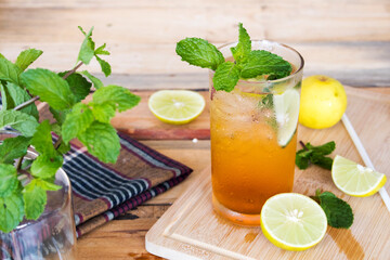 herbal healthy drinks cold lemon tea juice and lemon juice for health care with peppermint leaf and lemon slice on background wooden