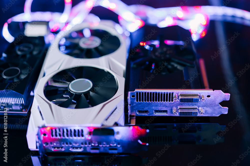 Fototapete graphics cards of different sizes and configurations on black table under neon light. part of comput