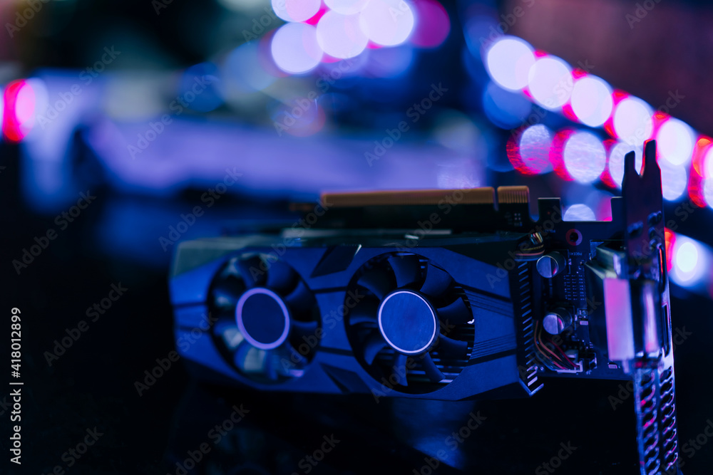 Poster black graphics card on black table under neon light. part of computer for gaming and cryptocurrency 