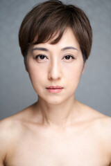 カメラ目線で真顔で見つめる中年の日本人女性