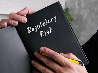  Financial concept about Regulatory Risk with inscription on the piece of paper.