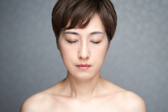正面を向いて目をつぶる中年の日本人女性