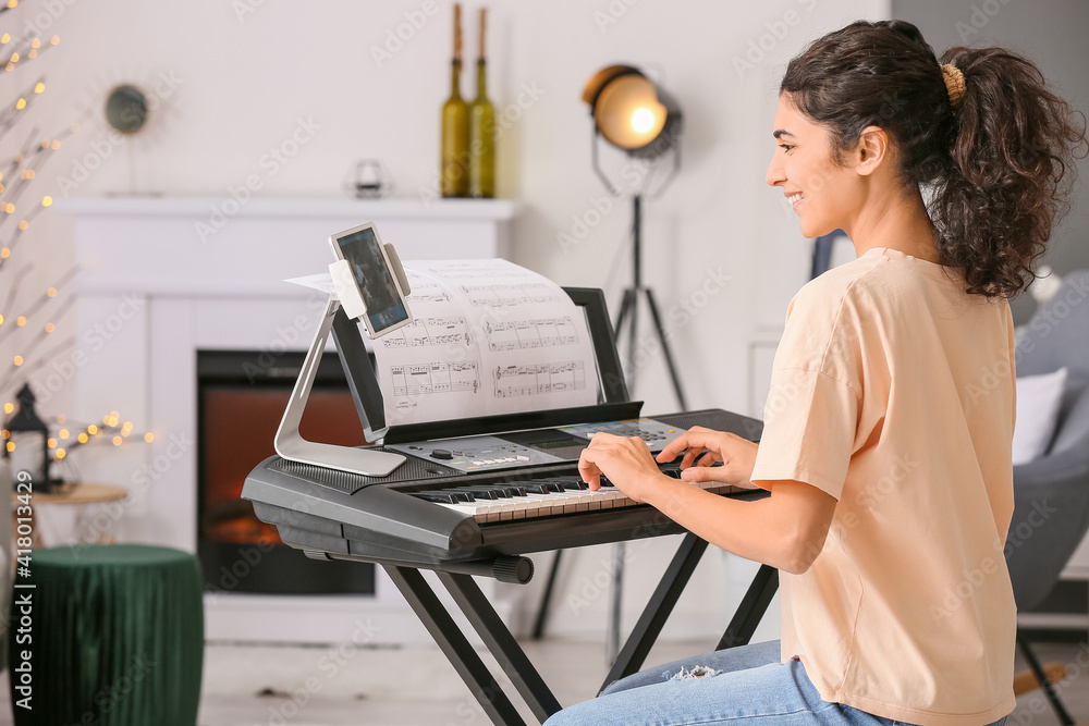 Canvas Prints Young woman giving music lessons online at home