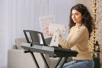 Young woman giving music lessons online at home