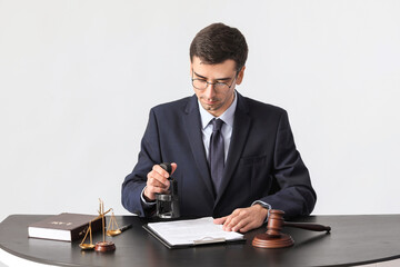 Male judge at table on grey background