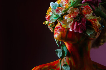 A model girl whose head is decorated with a headdress of fresh flowers that covers her eyes